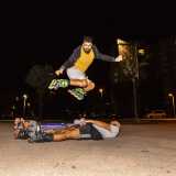 Ma � arrivato il momento di conoscere qualche altro skater. Ecco ad esempio il 25enne Antonio, che osserviamo mentre � in procinto di effettuare un salto spericolato. Dopo una notevole rincorsa resta sospeso in aria, superando cos� l�ostacolo rappresentato da cinque coraggiosi compagni distesi per terra
